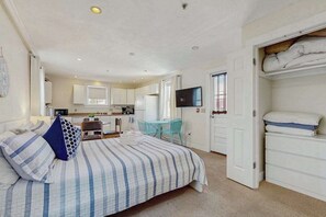 A bedroom with a bed, a desk, a TV, and a wardrobe. - Downtown studio w/ full kitchen - walk to Bay and shops! (Provincetown)