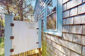 A utility box attached to a house with a sign requesting to bolt the shower door. - Charming Private Truro Cottage with Deck Near Bay Beaches (Truro)