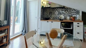 Eine moderne Küche mit einem Glastisch, weißen Schränken und einer gemusterten Spritzschutzwand.