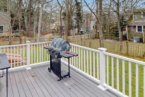 A deck with a grill, a table, and a white railing. - Dog friendly home w/ deck and private gas grill - on the bay side of the Cape (South Dennis)