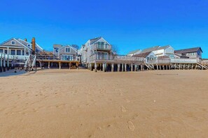 A beachside property with multiple buildings connected by wooden walkways over the sand. - Two-story condo with ocean views, parking, & private balcony (Provincetown)