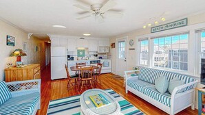 Un espacio habitable compacto con kitchenette, comedor y sofá.