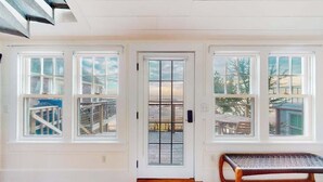 A room with a wooden floor, a bench, and a door with glass panels.