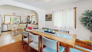 Una cocina amplia con comedor, muebles de madera y una planta grande.