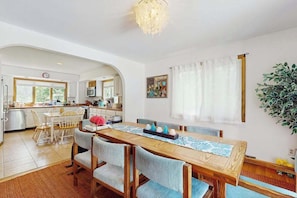 Una cocina amplia con comedor, muebles de madera y una planta grande.