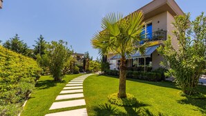 Un giardino curato con un vialetto centrale che conduce a un edificio con un balcone.