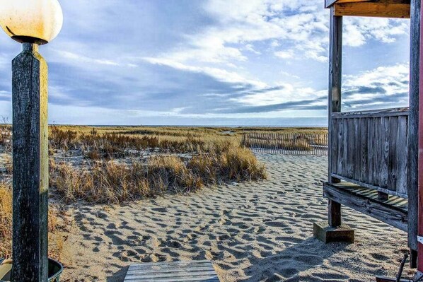 A wooden beach structure with a lamp post and a bench.