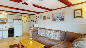 A living room with a brown sofa, wooden coffee table, and a ceiling fan.