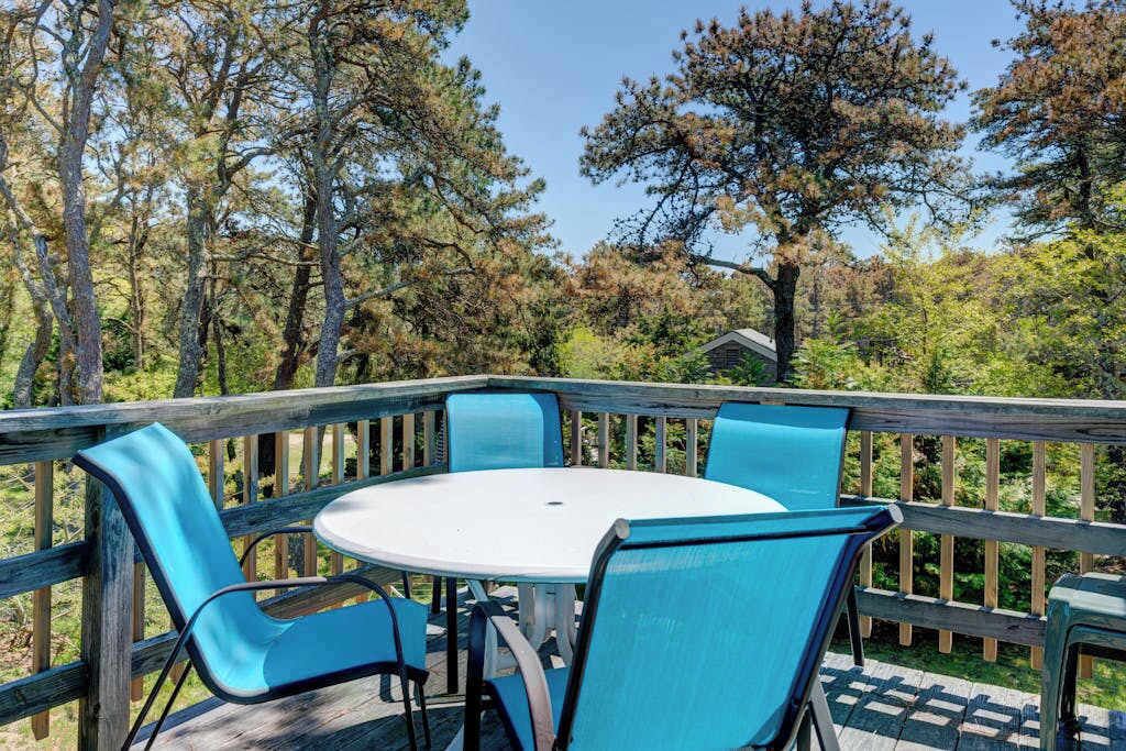 An outdoor deck with a round table and four chairs.