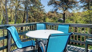 Eine Terrasse im Freien mit einem runden Tisch und vier Stühlen.