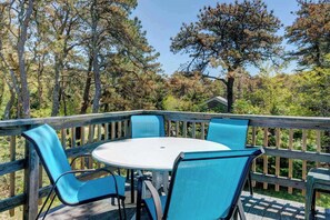 Eine Terrasse im Freien mit einem runden Tisch und vier Stühlen.