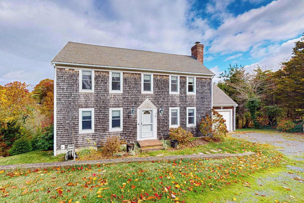 A two-story house with a front porch, a garage, and a driveway.