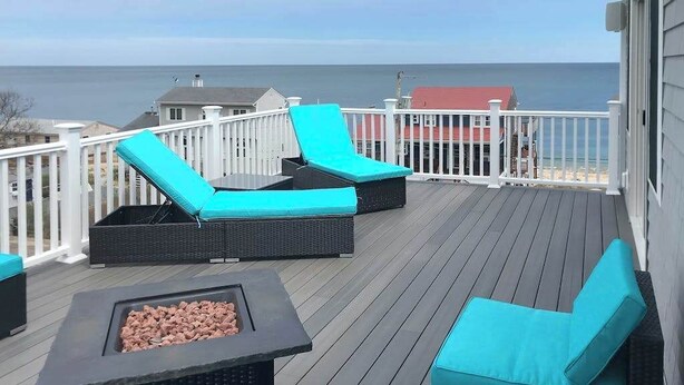 Eine Terrasse mit zwei Liegestühlen und einem Feuerkorb.