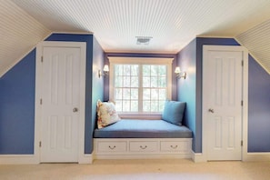 A room with a built-in bench seat, two doors, a window, and wall-mounted lamps. - Spacious home with huge deck & tree-lined yard, grill, & WiFi - great location (Orleans)