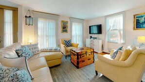 Ein Wohnzimmer mit einer Couch, einem Sessel und einer Holzkiste.