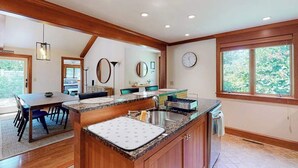 Une cuisine moderne dotée d’un îlot central, de meubles en bois et d’une grande fenêtre.