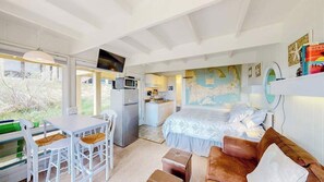 Ein Schlafzimmer mit Bett, Schreibtisch, Stuhl, einer Küchenzeile und einer Karte an der Wand.