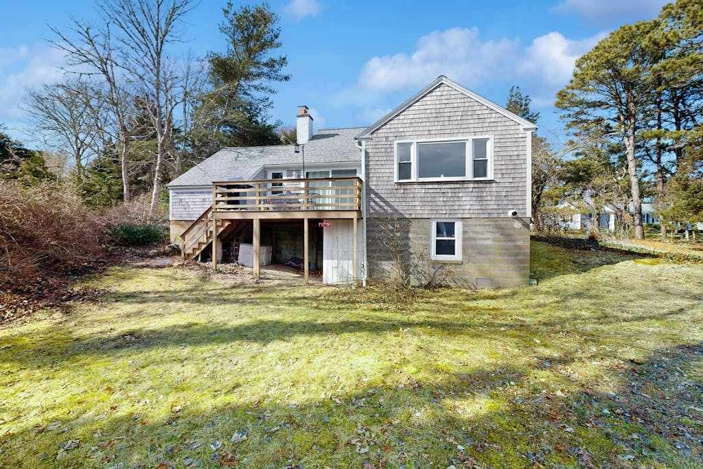 Une maison à deux étages avec un porche couvert et une petite terrasse.