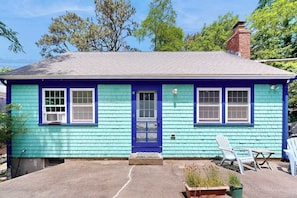 A single-story house with a blue exterior, a front door, and a small porch area.