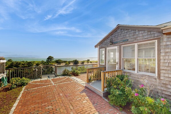 A wooden building with a deck, a view of the ocean, and a sign that says 'The Atlantic.'