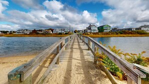 Une jetée en bois qui mène à des maisons situées au bord d’un lac.