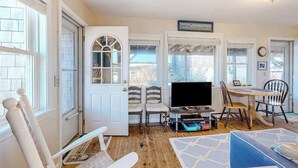 Ett mysigt vardagsrum med tv, sittgrupp och ett matbord.