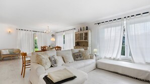 Una sala de estar con sofá, sillas, una mesa de comedor y un mueble aparador.