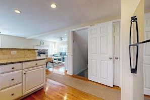 A kitchen with white cabinets, a granite countertop, and a refrigerator. - Classic home with deck, patio & yard - walk to Cockle Cove & Forest Beaches (South Chatham)