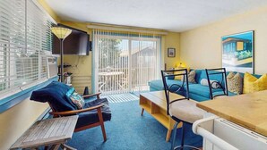 Ein Zimmer mit einer Sitzecke, Sesseln, einem Tisch und einem Fernseher.