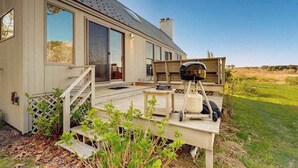 Une maison moderne dotée d’une terrasse, de grandes fenêtres et d’une cheminée.