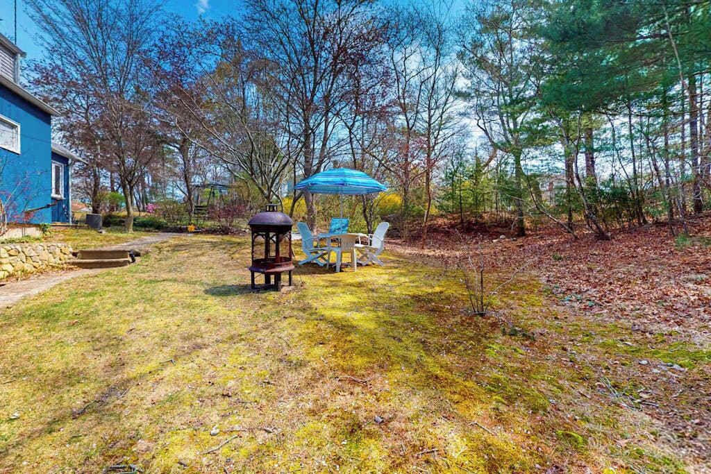 A backyard with a gazebo, outdoor seating, and a house.