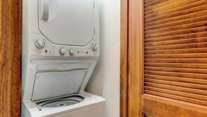 Una lavadora en un cuarto de lavado con puerta de madera.