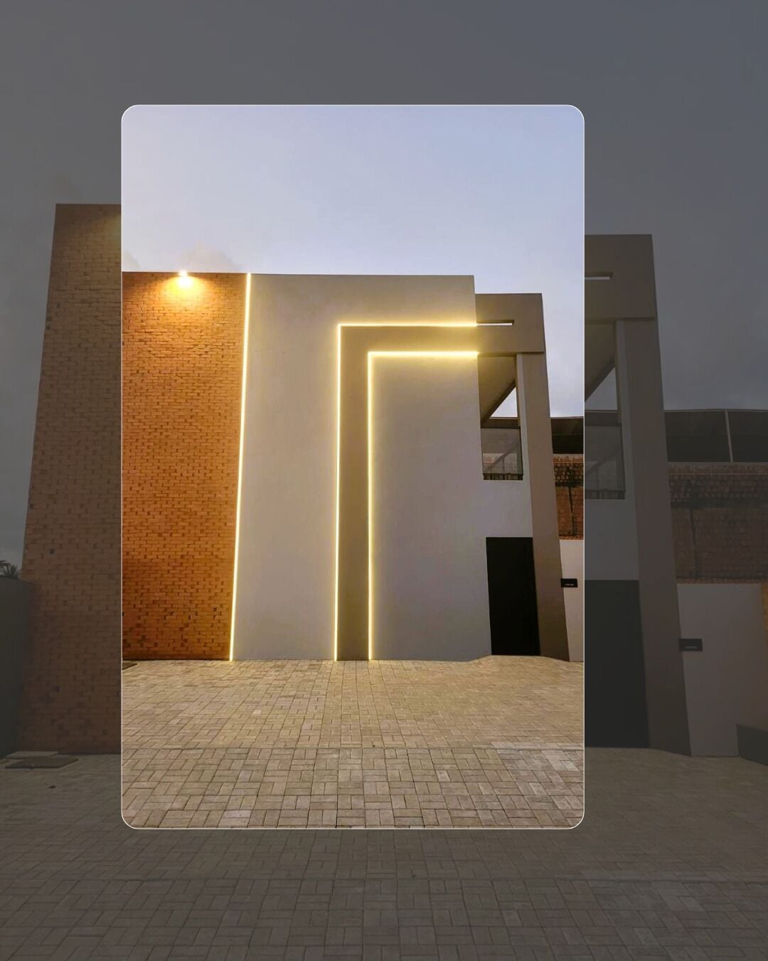 Un edificio moderno con fachada de ladrillo y entrada iluminada.