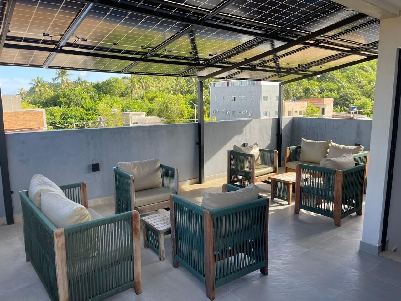 A rooftop terrace with outdoor furniture and solar panels.