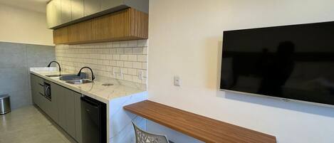 A modern kitchen with a built-in dishwasher, a sink, and a wooden countertop.