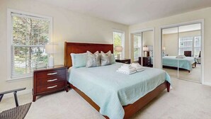 A bedroom with a large bed, a nightstand, a dresser, and a mirror. - Comfortable family getaway near the beach with patio, grill, WiFi and AC (West Yarmouth)