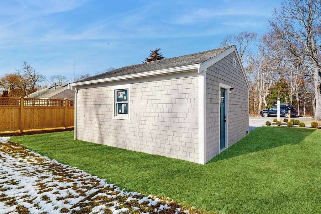 A small, single-story building with a sloped roof, a door, and a window.