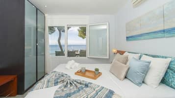 Un dormitorio con cama, mesita de noche, ventana con vistas y un cuadro en la pared.