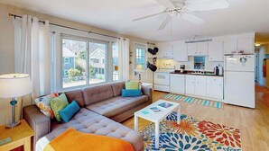Un apartamento moderno con sala de estar, cocina y ventanas amplias.
