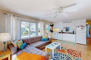 Un appartement moderne comprenant un salon, une cuisine et de grandes fenêtres.