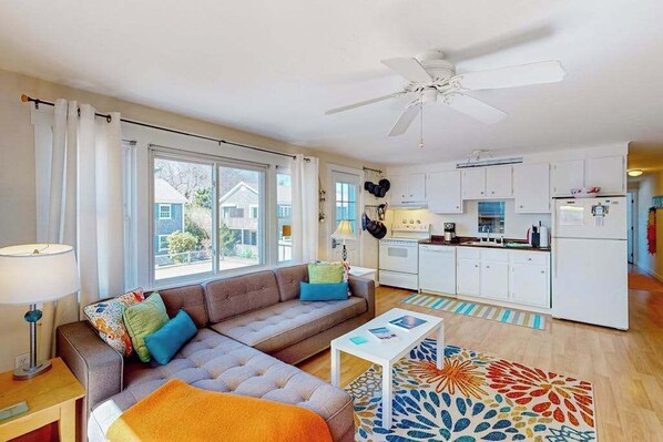 A modern apartment with a living room, kitchen, and large windows.