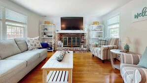A living room with a fireplace, a sofa, a coffee table, and a television.