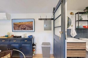 Une salle de bain moderne avec un lavabo blanc, un miroir et un porte-serviettes.