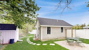 A small house with a patio and a shed. - Beautifully remodeled cottage near the beach with central AC, gas grill & lawn (Orleans)