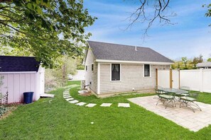 A small house with a patio and a shed. - Beautifully remodeled cottage near the beach with central AC, gas grill & lawn (Orleans)