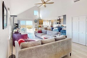 Ein geräumiger Wohnbereich mit einer großen Couch, einem Couchtisch und einer Stehlampe.