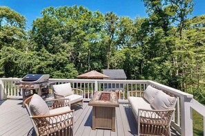 A deck with wicker furniture, a grill, and a fire pit. - North Falmouth House: Near Beach, Fire Pit, & Dog-Friendly! (North Falmouth)