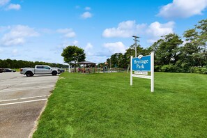 Heritage Park sign with a clear sky and a parking lot. - Modern Luxe on the Cape | Sleek Design, Central Air, Serene Views (Mashpee)