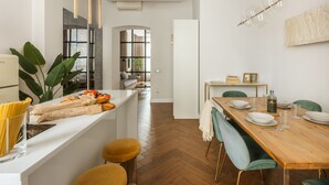 Una cocina moderna con comedor, suelo de madera e iluminación colgante.