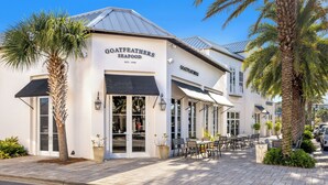 A seafood restaurant with outdoor seating and palm trees. - Resting BeachFace + Private Beach, Bikes & Games (Inlet Beach)